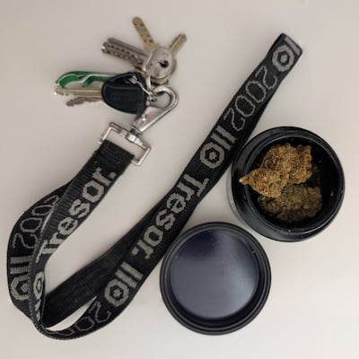 Goodies du Tresor : Un porte-clés et un grinder avec un peu de cannabis.